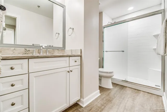 a bathroom with a granite countertop sink a toilet and a mirror