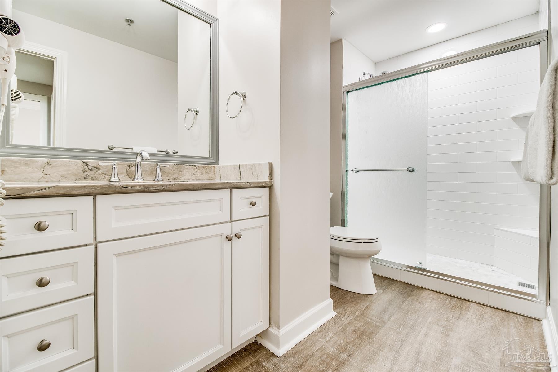 13601 Perdido Key Drive, Unit W18C Perdido Key, FL 32507 - Photo 10 of 30 a bathroom with a granite countertop sink a toilet and a mirror