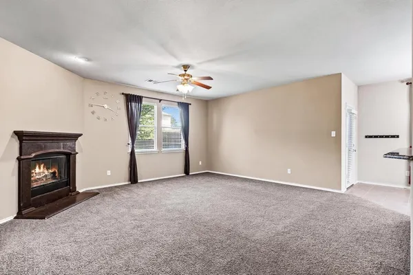 an empty room with windows and fireplace