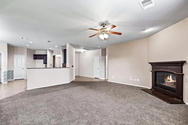a view of a room with a fireplace and a chandelier fan
