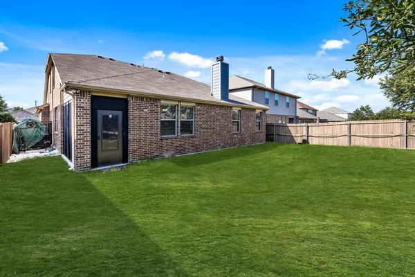a view of a house with a yard and a large tree