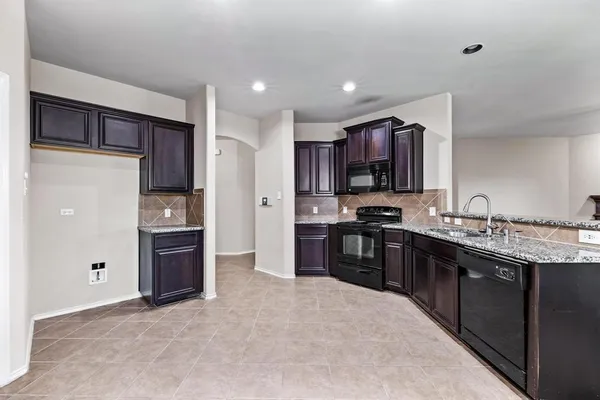 a large kitchen with stainless steel appliances and a refrigerator