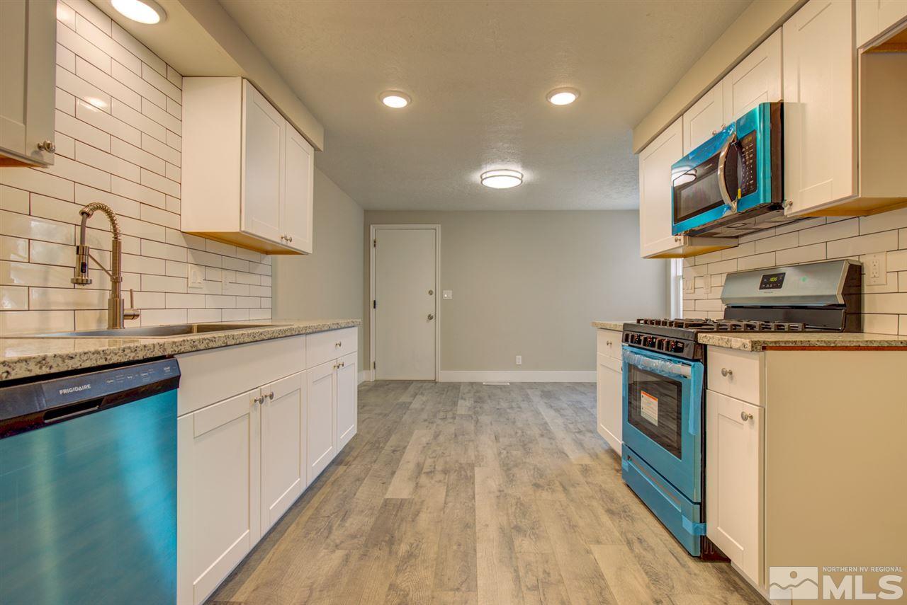 6755 Lotus Street Reno, NV 89506 - Photo 11 of 27 a kitchen with stainless steel appliances granite countertop a stove and a sink