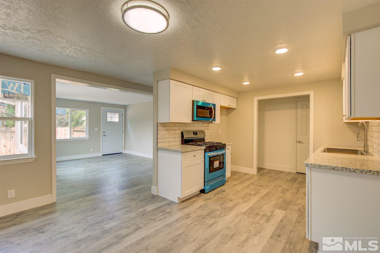 6755 Lotus Street Reno, NV 89506 - Photo 5 of 27 a kitchen with granite countertop a stove and a sink