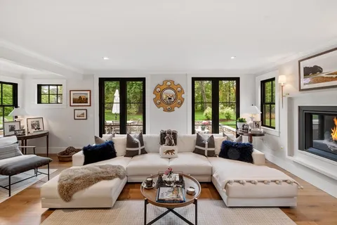 a living room with furniture fireplace and window