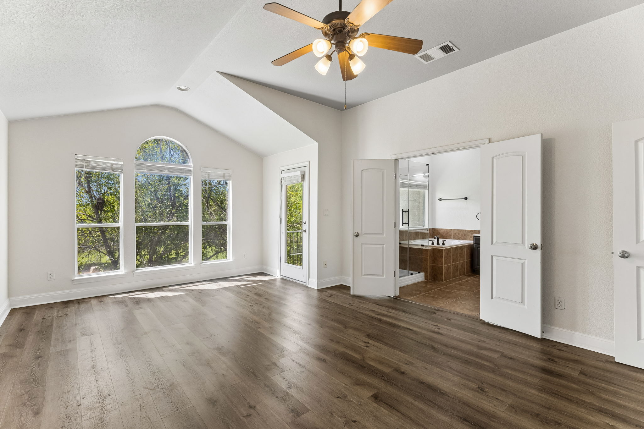 114 Aria Ridge, Unit 802 Lakeway, TX 78738 - Photo 28 of 37 An airy primary bedroom features ample windows and direct access to a spa-like bath.