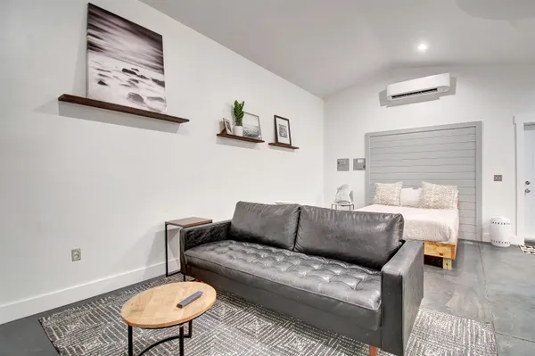a living room with furniture and a wooden floor
