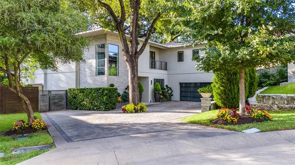 a front view of a house with a yard and potted plants