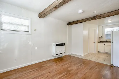 wooden floor in an empty room with a kitchen