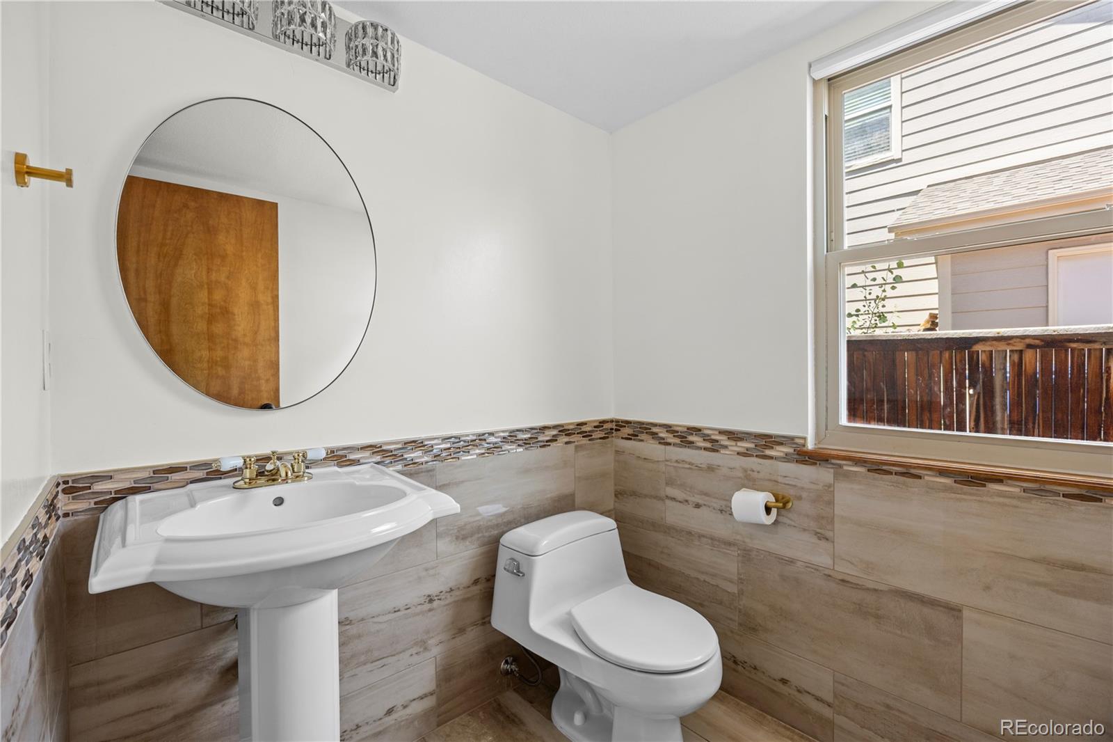 8725 Meadowlark Circle Highlands Ranch, CO 80126 - Photo 15 of 40 a bathroom with a sink a toilet and a mirror
