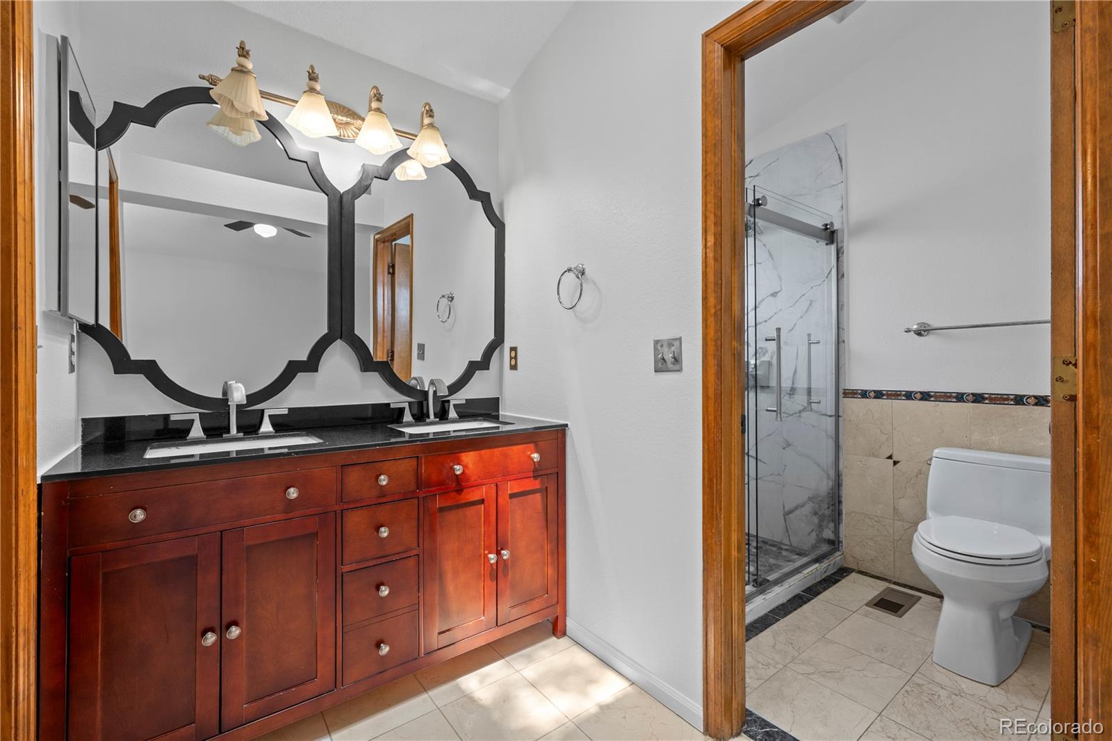 8725 Meadowlark Circle Highlands Ranch, CO 80126 - Photo 19 of 40 a bathroom with a toilet a sink and mirror