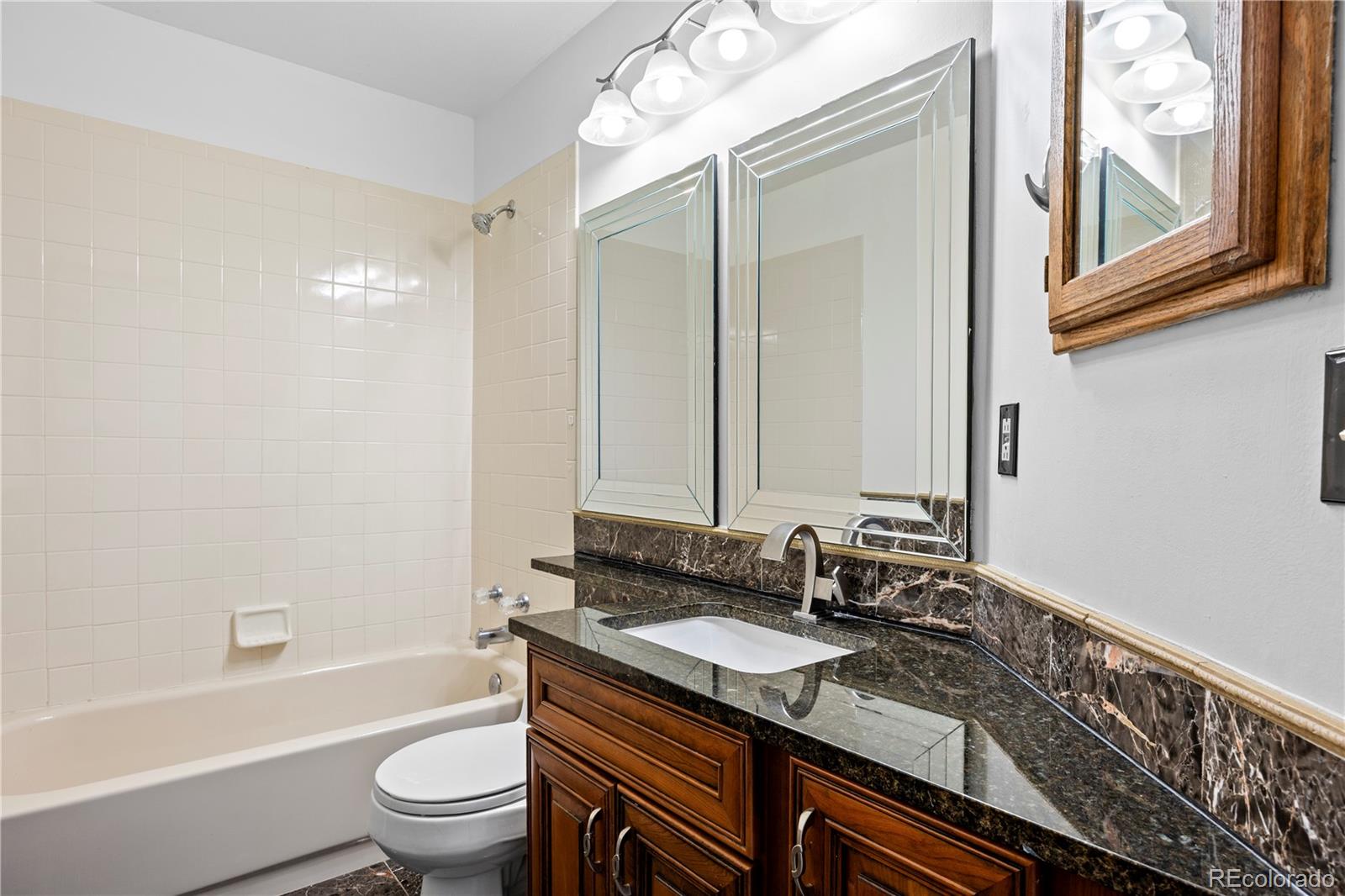 8725 Meadowlark Circle Highlands Ranch, CO 80126 - Photo 23 of 40 a bathroom with a granite countertop sink toilet and shower