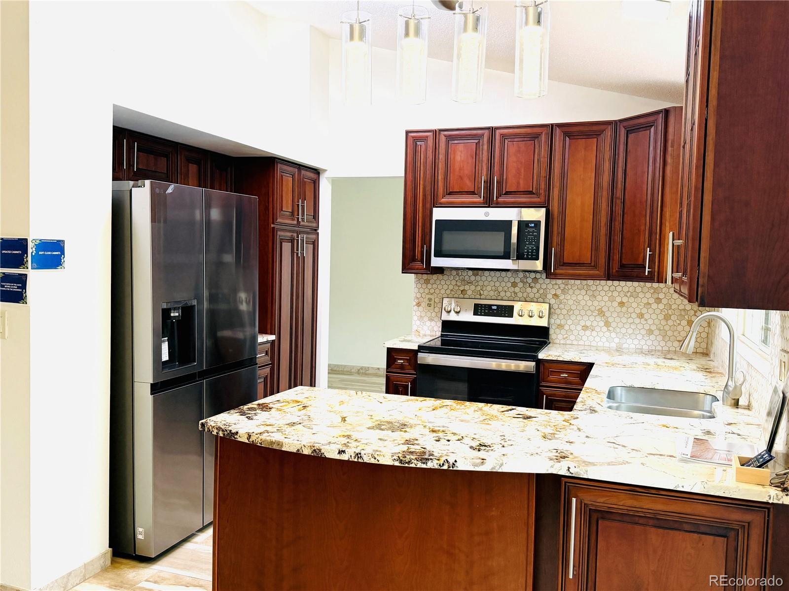 8725 Meadowlark Circle Highlands Ranch, CO 80126 - Photo 8 of 40 a kitchen with granite countertop a stove refrigerator and microwave