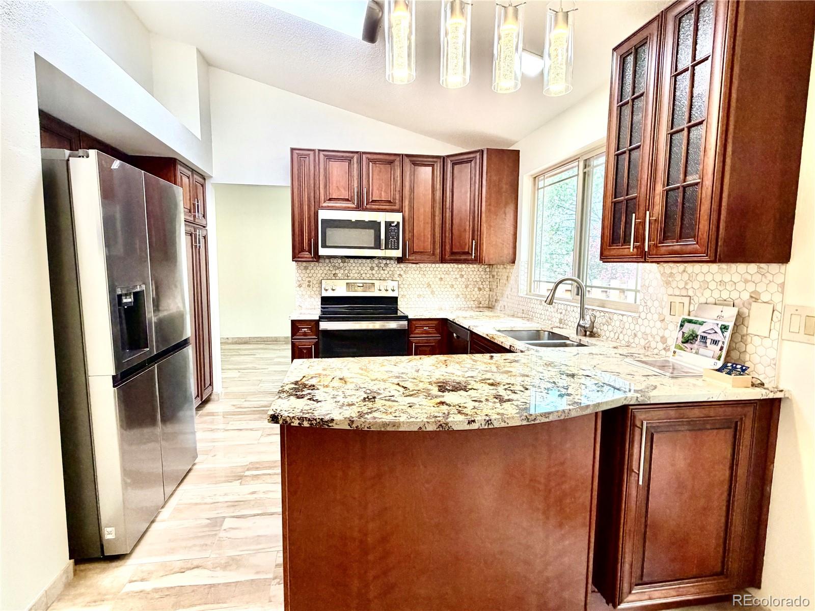 8725 Meadowlark Circle Highlands Ranch, CO 80126 - Photo 10 of 40 a kitchen with kitchen island granite countertop a refrigerator stove and sink