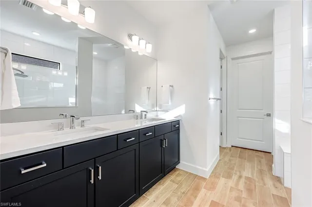 a spacious bathroom with a double vanity sink and mirror