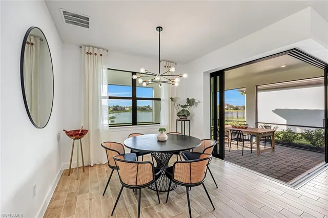 a dining room with furniture a chandelier and wooden floor