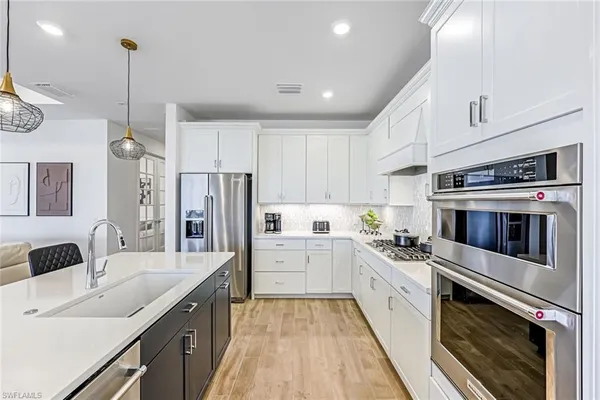 a kitchen with white cabinets and stainless steel appliances
