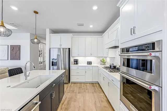 a kitchen with white cabinets and stainless steel appliances