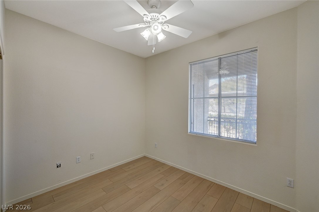 9050 West Warm Springs Road, Unit 1147 Las Vegas, NV 89148 - Photo 30 of 36 A quiet secondary bedroom features light wood-look flooring and a ceiling fan for comfort.
