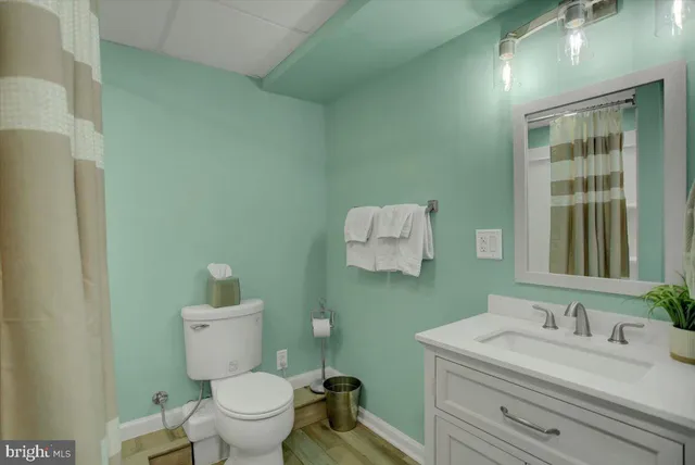 a bathroom with a toilet sink vanity and mirror