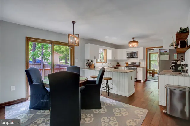 a dining room with furniture a chandelier and wooden floor
