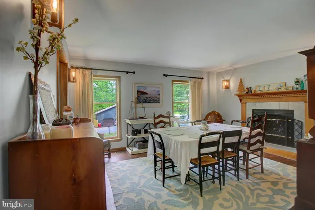 a dining room with furniture a fireplace and large windows