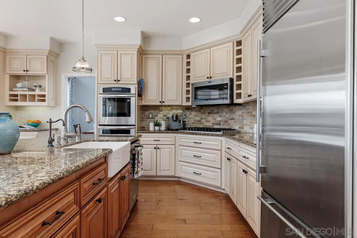 6943 Wildrose Terrace Carlsbad, CA 92011 - Photo 14 of 34 a kitchen with stainless steel appliances granite countertop a sink stove and refrigerator