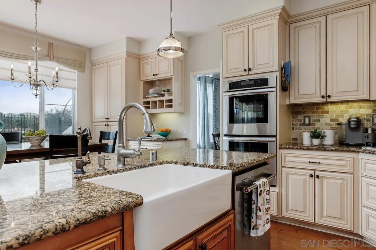 6943 Wildrose Terrace Carlsbad, CA 92011 - Photo 15 of 34 a kitchen with stainless steel appliances granite countertop a stove top oven a sink a counter space and cabinets