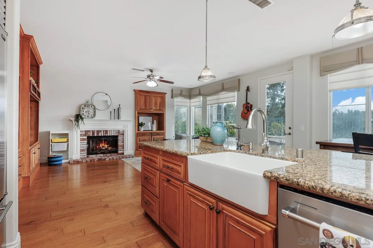 6943 Wildrose Terrace Carlsbad, CA 92011 - Photo 17 of 34 a large living room with fireplace furniture and a wooden floor