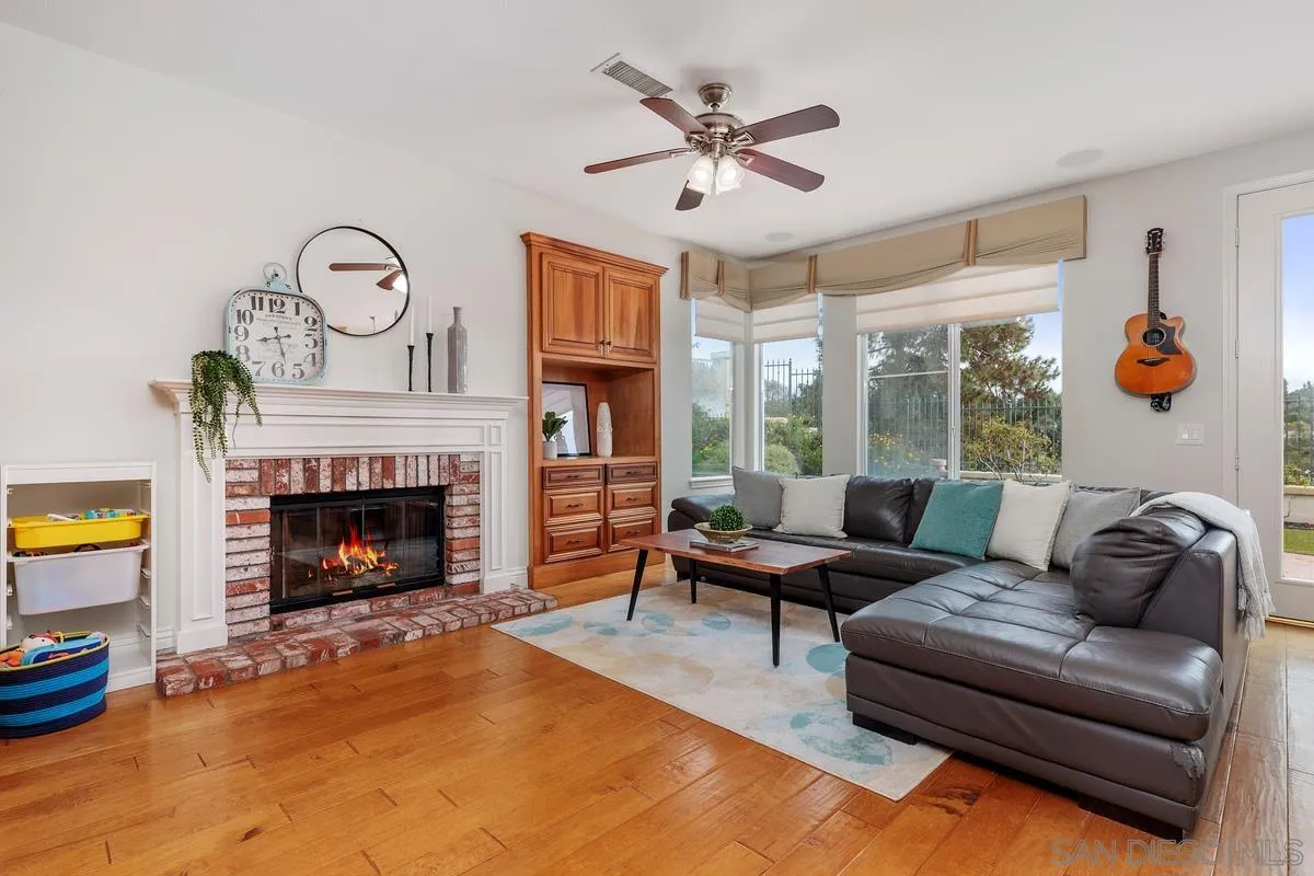 6943 Wildrose Terrace Carlsbad, CA 92011 - Photo 19 of 34 a living room with furniture a fireplace and a flat screen tv