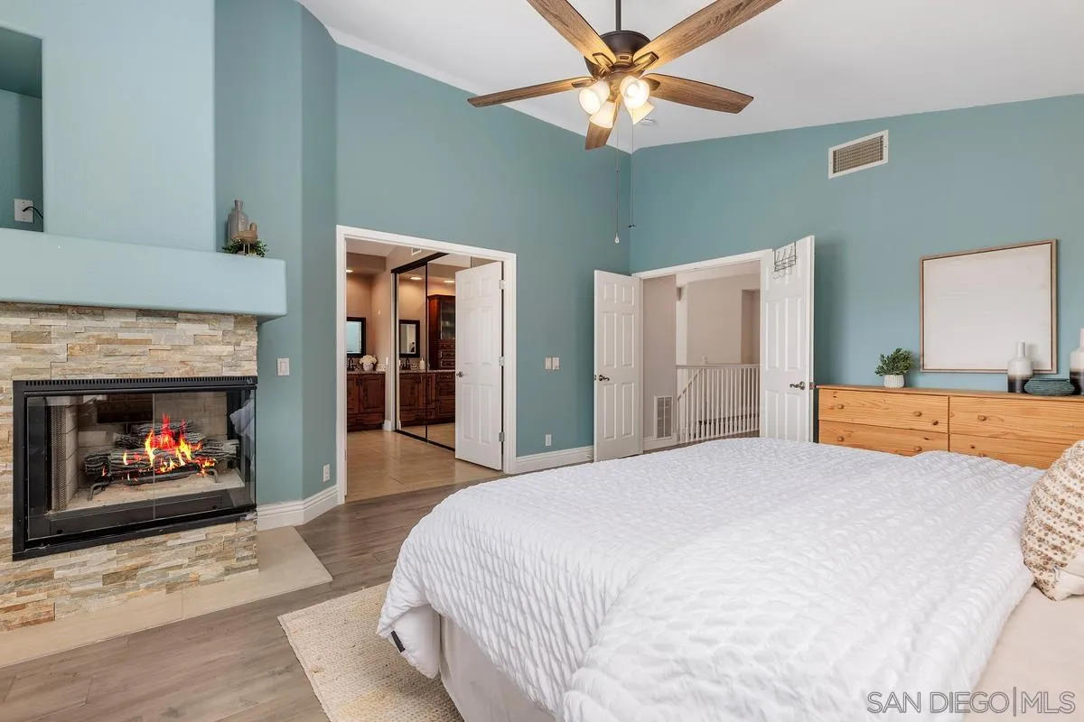 6943 Wildrose Terrace Carlsbad, CA 92011 - Photo 26 of 34 a spacious bedroom with a bed and a fireplace