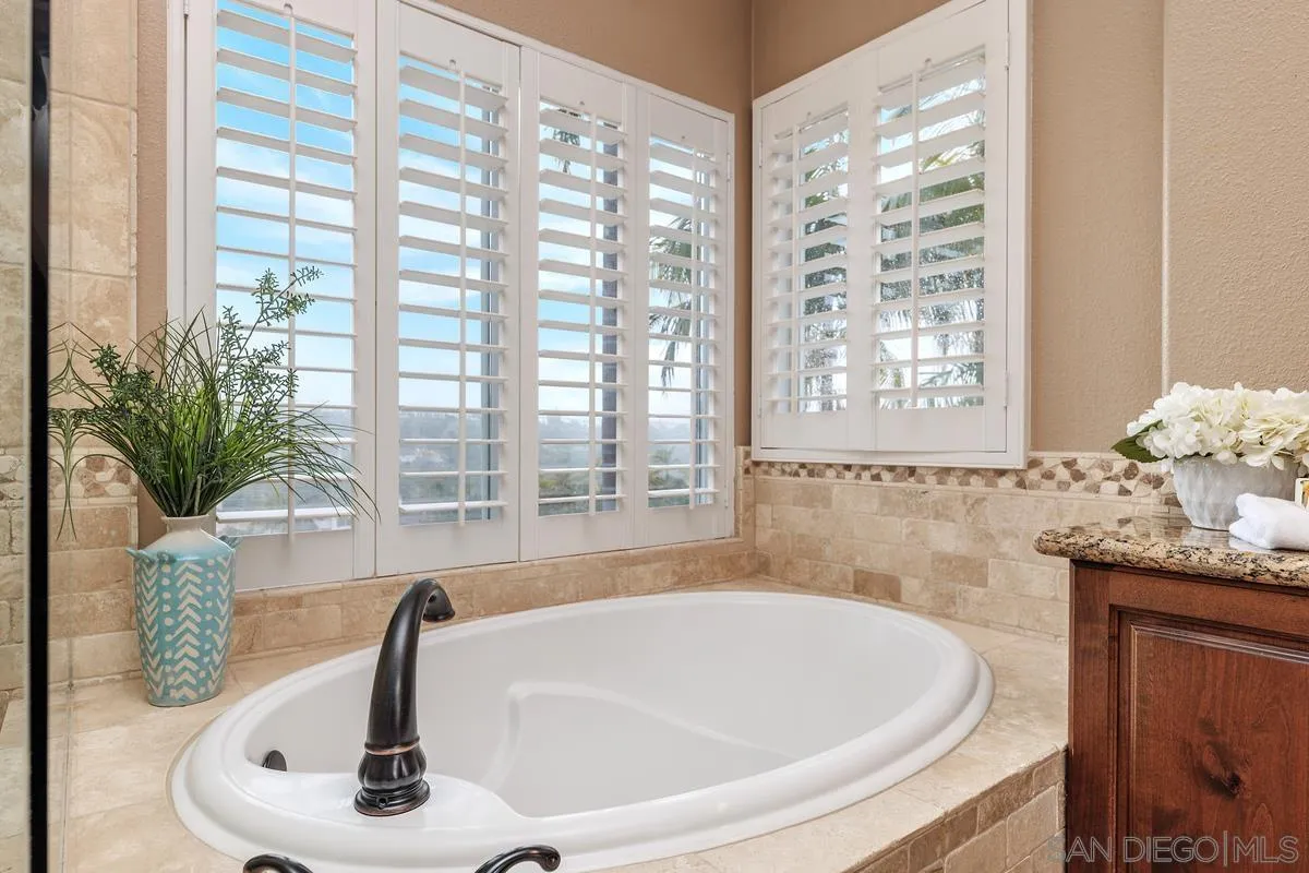6943 Wildrose Terrace Carlsbad, CA 92011 - Photo 28 of 34 a bath tub sitting in a bathroom next to a window