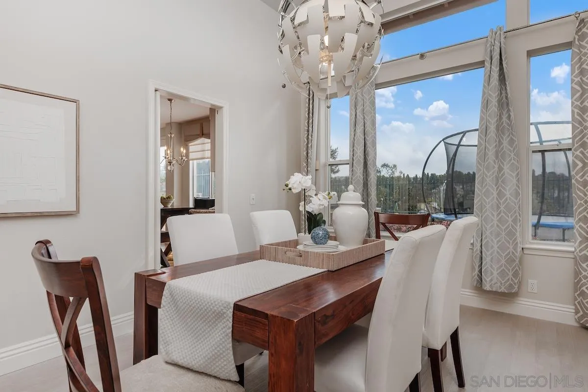 6943 Wildrose Terrace Carlsbad, CA 92011 - Photo 10 of 34 a view of a dining room with furniture a chandelier and wooden floor
