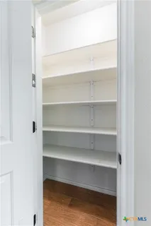 a view of walk in closet with empty racks