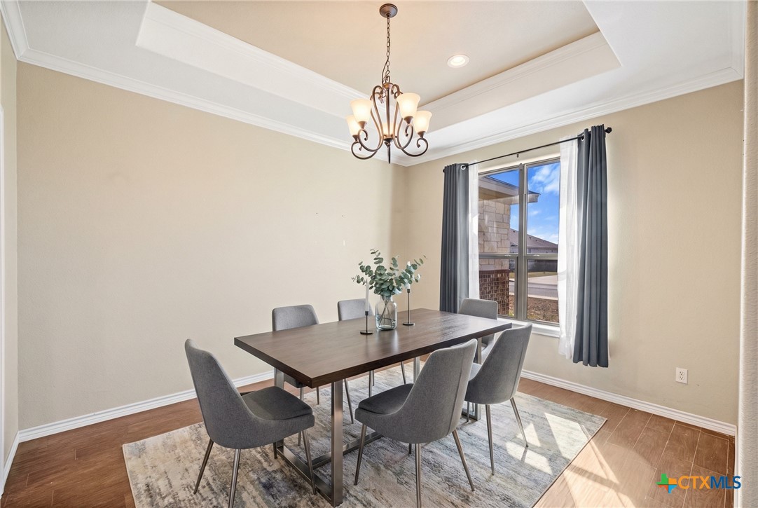 304 Jake Drive Jarrell, TX 76537 - Photo 12 of 30 a dining room with wooden floor a chandelier a wooden table and chairs