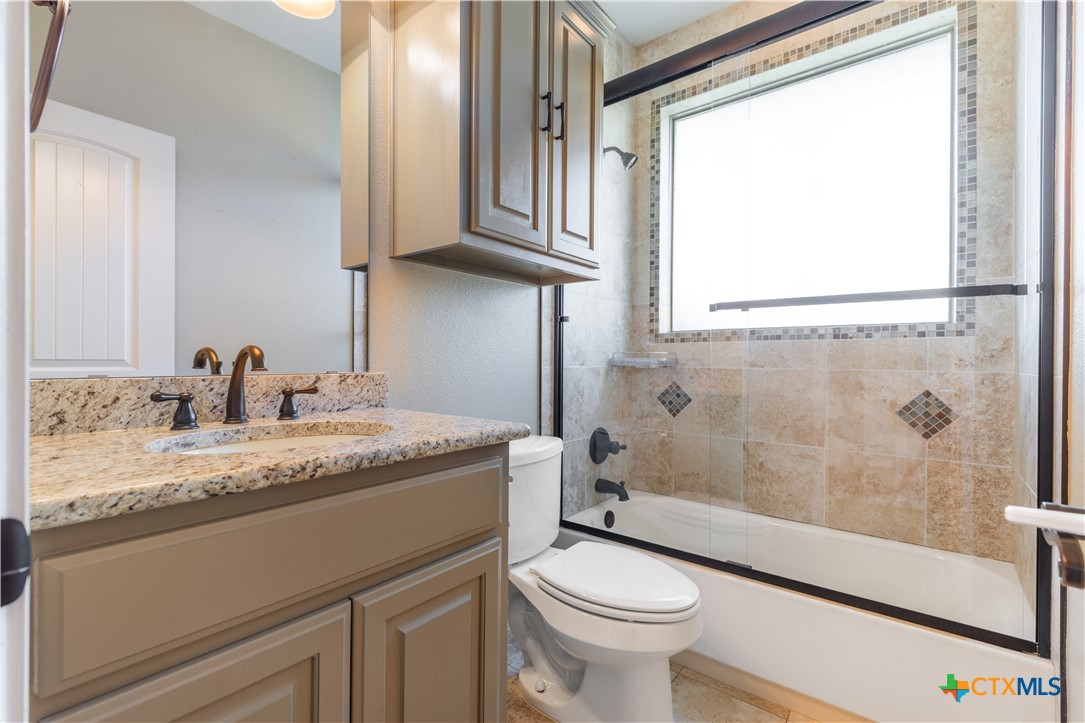 304 Jake Drive Jarrell, TX 76537 - Photo 24 of 30 a bathroom with a granite countertop sink toilet and shower