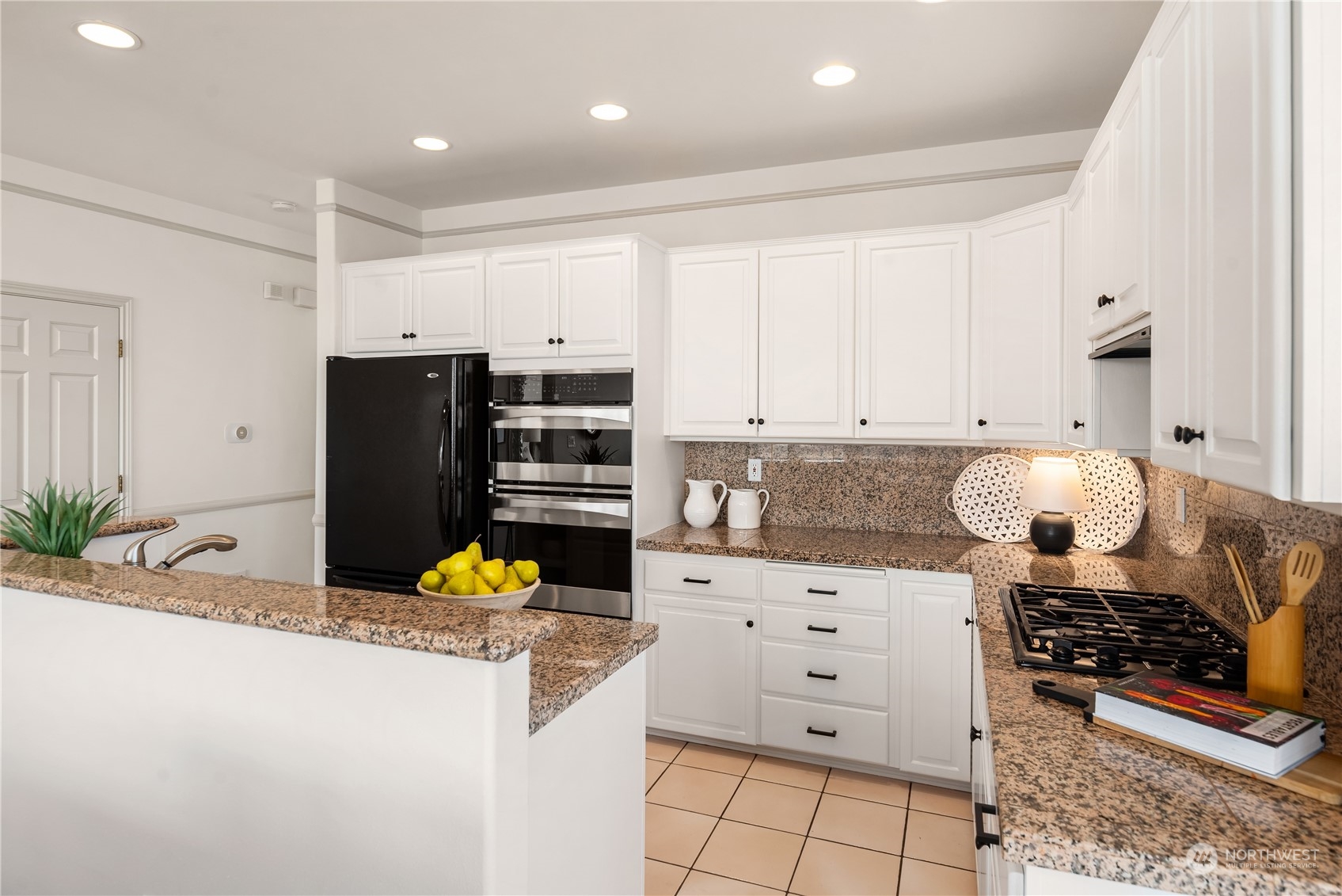 2349 Harbor Avenue Southwest, Unit 705 Seattle, WA 98126 - Photo 16 of 34 a kitchen with stainless steel appliances kitchen island granite countertop a refrigerator and a stove