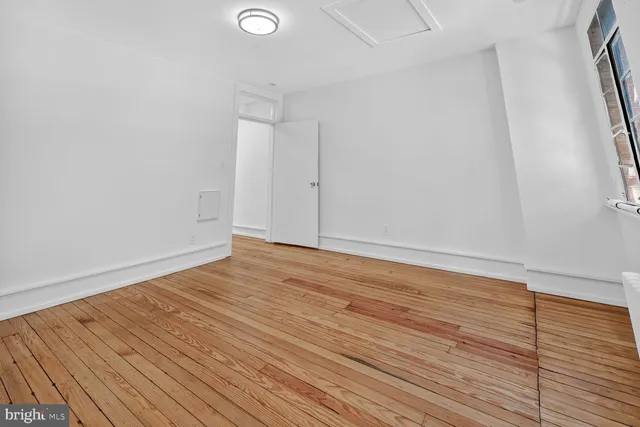 a view of an empty room with wooden floor