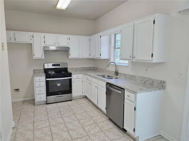 a kitchen with stainless steel appliances cabinets a sink and a stove