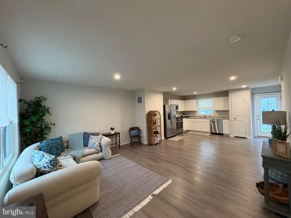 a living room with furniture and a table with wooden floor