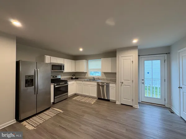 a kitchen with stainless steel appliances a refrigerator and a stove top oven