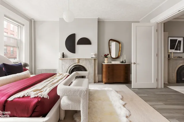 a bedroom with a bed a mirror and window