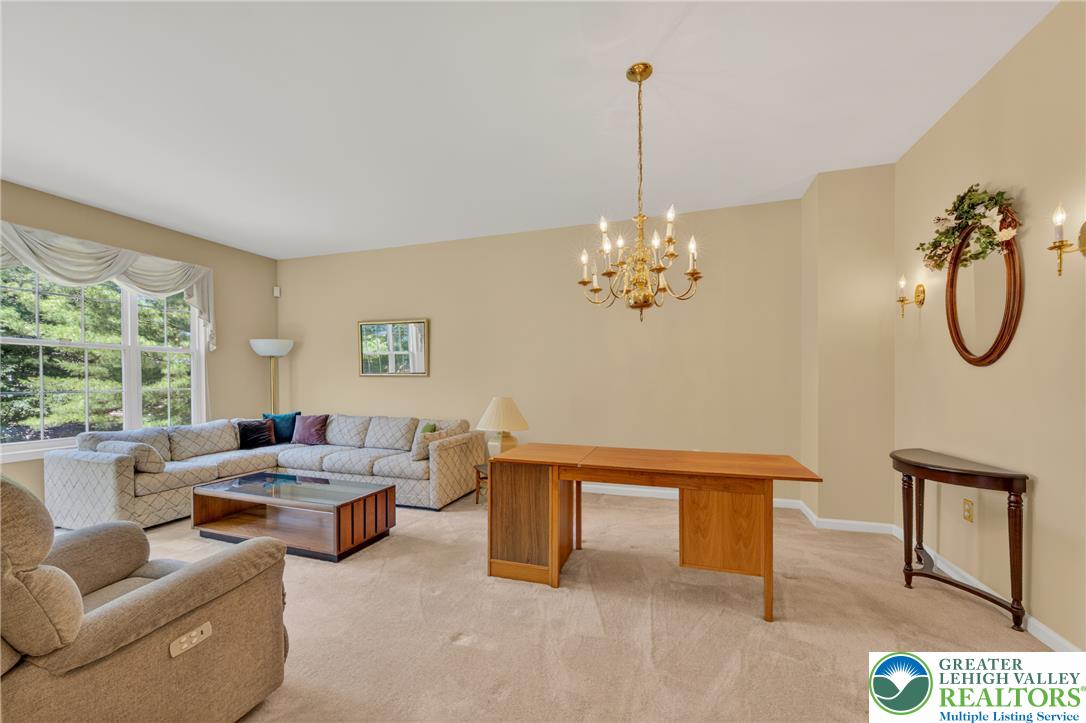4345 Creek Road Allentown, PA 18104 - Photo 14 of 33 A refined living room with dining area that boasts a classic chandelier, offering a bright and welcoming atmosphere.