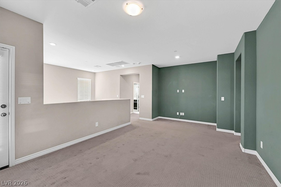 1106 Langston Ranch Avenue Henderson, NV 89002 - Photo 12 of 36 A spacious common area with plush carpet flooring offers a versatile layout and bright illumination.