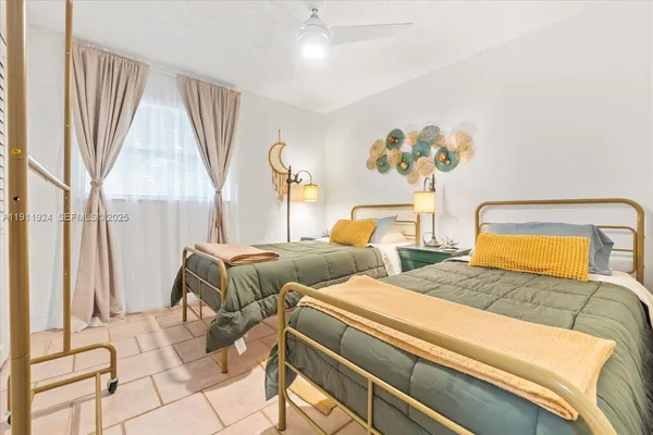 a bedroom with two beds and a large window