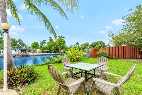a view of a chairs and table in patio with swimming pool