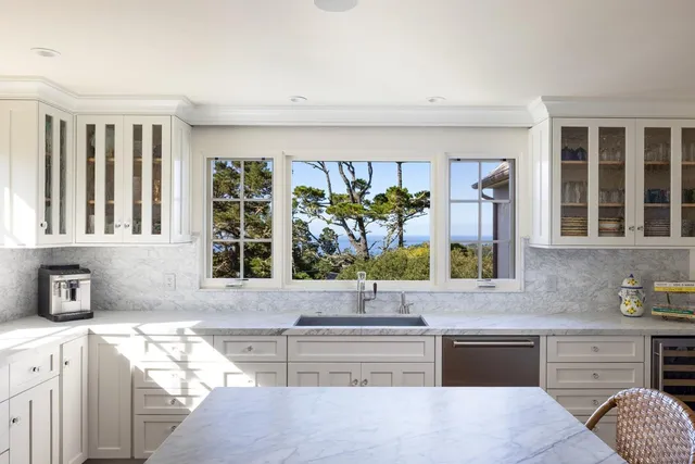 a kitchen with stainless steel appliances kitchen island wooden cabinets and a window