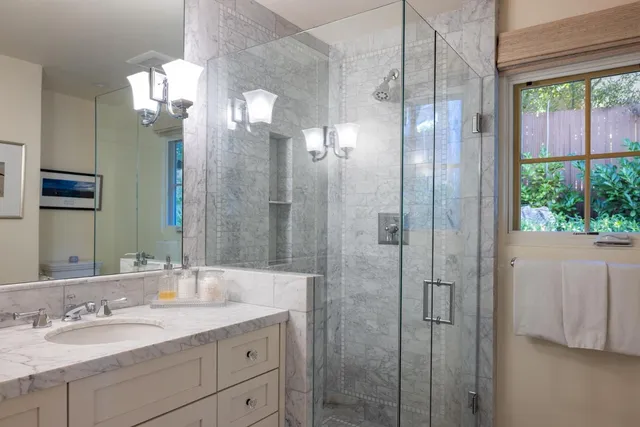 a bathroom with a granite countertop sink a shower and a mirror