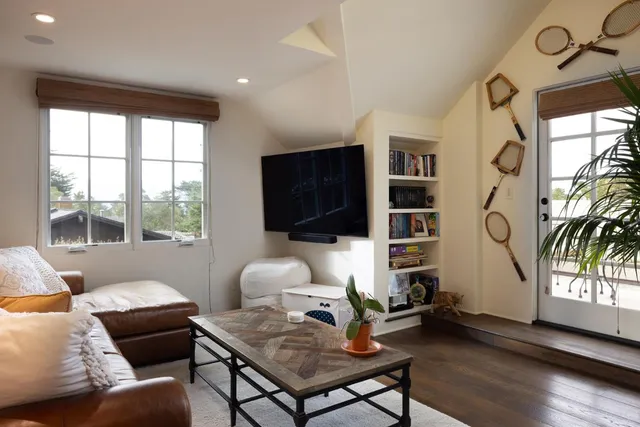 a living room with furniture a flat screen tv and a large window