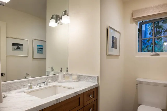 a bathroom with a sink toilet and a mirror